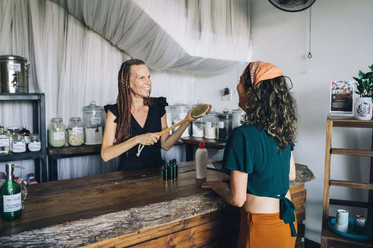 our-services-1 A customer buying natural skincare products from a cheerful shop owner.